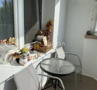 Balkon s dekoracemi a stolem v 2pokojovém bytě nabízí příjemné posezení.