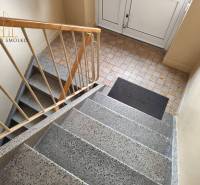 Schodiště v bytovém domě na Mírové ulici v Sabinově s dlažbou.