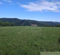 Krásné zelené pozemky k bydlení v Horním Tisovníku s panoramatem lesa a modré oblohy.