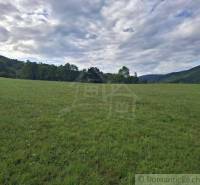 Rozlehlá zelená louka obklopená lesy a kopci v okolí Horního Tisovníka, Pozemky - bydlení.