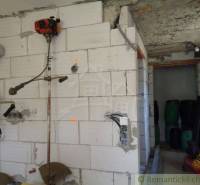 Interiér rodinného domu s nářadím na stěně a skladovacími sudy v Šiatorské Bukovince.