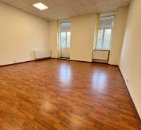 Kanceláře s podlahou s dřevěným dekorem, světlý interiér s velkými okny.