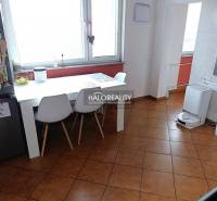 Jídelna v 2-pokojovém bytě s bílým stolem a hnědou podlahou.