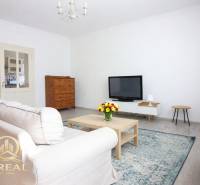 Obývací pokoj s televizí, pohovkou a konferenčním stolkem v 1-pokojovém bytě.