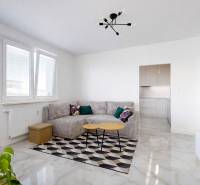 Obývací pokoj s rohovou sedačkou, jídelním stolem a balkonem ve 3pokojovém bytě.