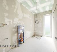Interiér chaty s neomítnutými stěnami a přípravou na instalaci sanitárního zařízení.