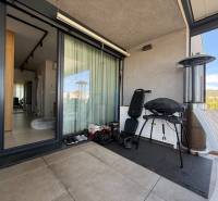 Balkon 4pokojového bytu s grilem, židlí a výhledem na Dúbravku.