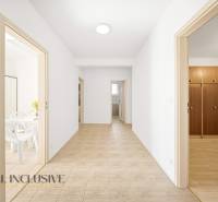 Chodba v rodinném domě s dveřmi do pokojů a dlažbou na podlaze.