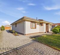 Rodinný dům v Kútnikách s dlážděným chodníkem a udržovanou zahradou.