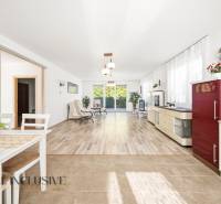 Interiér rodinného domu se světlým obývacím pokojem a podlahou s dřevěným dekorem.