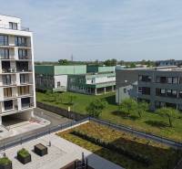 Pohled na obytné budovy a zeleň na Eduarda Wenzla v Bratislavě-Rači, garáže vpravo.