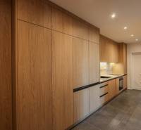 Kuchyně ve 3-pokojovém bytě s podlahou s dřevěným dekorem a vestavěnými spotřebiči.