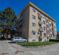 Bytový dům se zaparkovaným autem na Sasinkově ulici v Piešťanech.