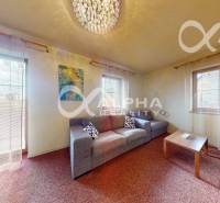 Obývací pokoj v 2-pokojovém bytě s pohovkou, kobercem a stropním světlem.