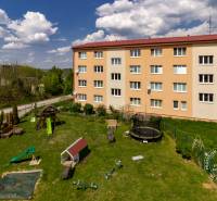 Bytový dům na ulici Vincenta Šikuly ve Stupavě, s dětským hřištěm v popředí.