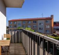 Balkon 2-pokojového bytu na Vincenta Šikulu ve Stupavě, s venkovním posezením a zelení.