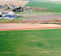 Pozemek v zahradách Ondřejovic, ohraničený červenou linií, obklopený otevřenou krajinou.