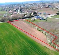 Letecký pohled na zemědělskou plochu v Ondřejovicích obklopenou zahradami a vesnicí.