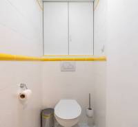 Koupelna s bílými kachličkami a žlutými detaily v Rekreačním apartmánu.