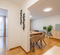 Interiér rekreačního apartmánu s podlahou s dřevěným dekorem, jídelnou a ložnicí.