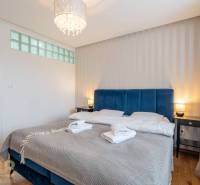 Ložnice v rekreačním apartmánu s manželskou postelí a podlahou s dřevěným dekorem.