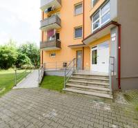 Bytový dům na Armádní ulici v Trenčíně s přístupovými schody a zelení.