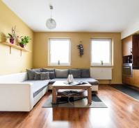 Obývací pokoj v 2pokojovém bytě s kuchyní a podlahou s dřevěným dekorem.