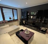 Obývací pokoj ve 2-pokojovém bytě s moderním nábytkem a dlažbou na podlaze.