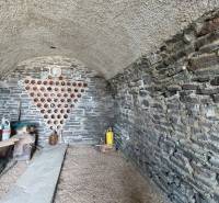 Kamenný sklep ve vinici s úložným prostorem na víno a policí na nádoby.