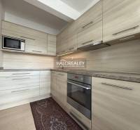 Kuchyně v rodinném domě s linkou a podlahou s dřevěným dekorem.