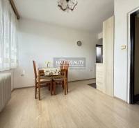 Jídelna s podlahou s dřevěným dekorem, stolem a židlemi v rodinném domě.