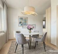 Jídelní kout v rodinném domě s kulatým stolem a elegantním svítidlem.