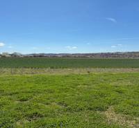 Zemědělské a lesní pozemky v Dežericích s rozlehlými loukami a jasnou oblohou.