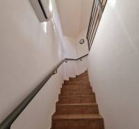 Interiér obchodních prostor s keramickými schody a bílými stěnami.