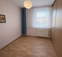Pokoj v 2-pokojovém bytě s podlahou s dřevěným dekorem a velkou vestavěnou skříní.