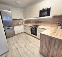 Kuchyně s podlahou s dřevěným dekorem v 2-pokojovém bytě s moderní linkou.