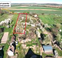 Zahradní parcela v Gemeru s přístupovou cestou, obklopená kvetoucími stromy a poli.