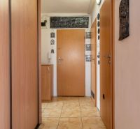 Chodba se skříní a dlažbou ve 4-pokojovém bytě.