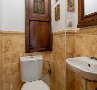 WC s dřevěnými dveřmi a zrcadlem, keramické obklady, umyvadlo ve 4-pokojovém bytě.