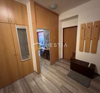 Předsíň v 3-pokojovém bytě s dřevěným dekorem a vestavěnými skříněmi.