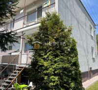 Bytový dům v Brezové pod Bradlom s balkony a schodištěm do zahrady.