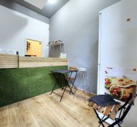 Gastro prostory s pultem, židlemi a podlahou s dřevěným dekorem.