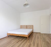 Ložnice s postelí a podlahou s dřevěným dekorem ve 3-pokojovém bytě.