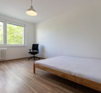Světlá ložnice ve 3pokojovém bytě s podlahou s dřevěným dekorem a velkými okny.