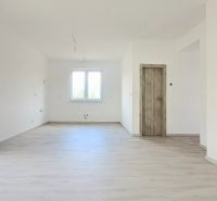 Interiér rodinného domu s oknem a podlahou s dřevěným dekorem.