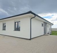 Rodinný dům v Topoľnici s bílou fasádou a dlážděným nádvořím.