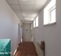 Chodba v rodinném domě s dlažbou, světlými stěnami a stropními panely.