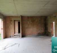Interiér rodinného domu s cihlovými stěnami a betonovou podlahou, vhodný k úpravě.