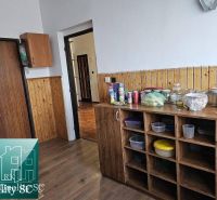 Kuchyně s dřevěným dekorem v rodinném domě s potravinami a skladovacími prostory.