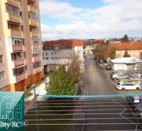 Pohled z 1-pokojového bytu na Náměstí 1. máje v Senci, ulice a parkoviště.
